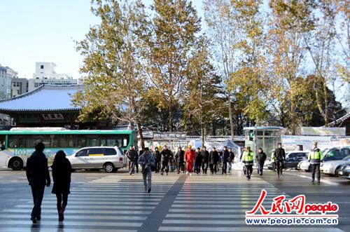 首尔市厅路口,行人正在交警的指挥下有秩序的过马路 摄影记者:孙伟东
