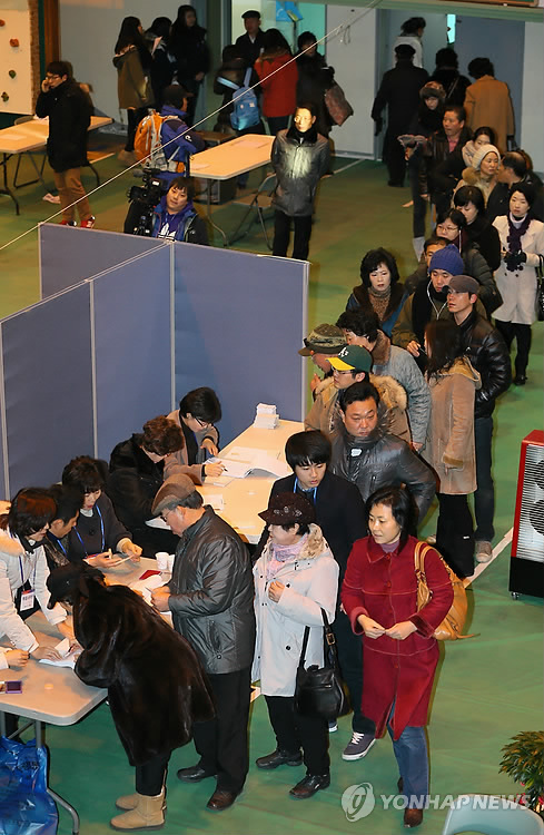 资料图片:首尔蚕室地区选民们排长队等候投票。(图片来自韩联社)