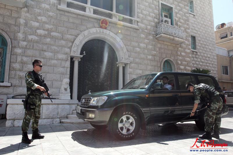 由于中国、俄罗斯在叙利亚问题上所持的“坚决反对外来军事干预”和政治解决危机的一贯立场,叙利亚反对派武装多次公开恐吓,并企图袭击中国使馆的目标。张迅大使说,“我们接到过多次恐吓和试图袭击我们的情报。”
“最惊险的是今年三四月份,”张迅大使透露,“叙利亚反恐情报机构向我们通报称,使馆一名叙利亚雇员2月前往约旦时可能被反对派策反,有对中国外交官不利的企图。”大使馆赶紧对数名雇员进行情况摸底,结果发现一名叫巴赞姆的司机几个月前曾请假外出,回来后行为有些反常,他常待在使馆里不愿外出,对其他叙利亚同事也有躲避行为。几天后,这名司机被叙反恐安全人员逮捕。他后来承认,他确实是在约旦时与反对派武装挂上钩,然后回国继续在中国使馆潜伏,伺机在使馆车辆里安装爆炸物。图为派驻叙利亚的中国武警严密检查每一辆进出使馆车辆。(人民网驻叙利亚记者 焦翔摄)