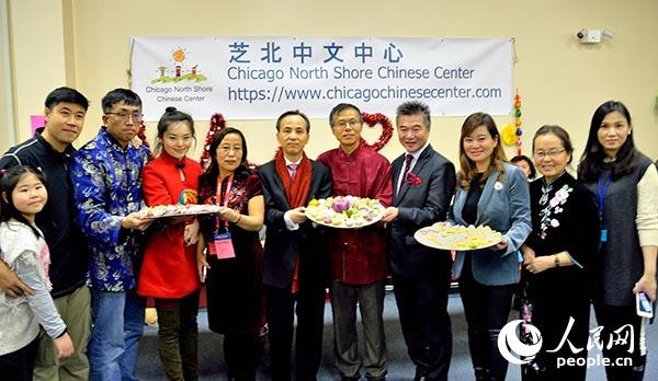 刘军代总领事、华联会主席郑征、太古广场总裁倪举凌等与芝北中文中心的饺子摊位的师生义工们合影。(张大卫 摄)