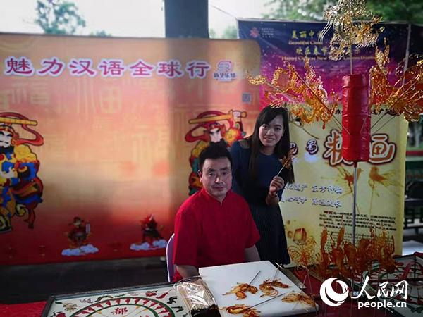 四川著名糖画老师谢峰坤老师与体验者合影。