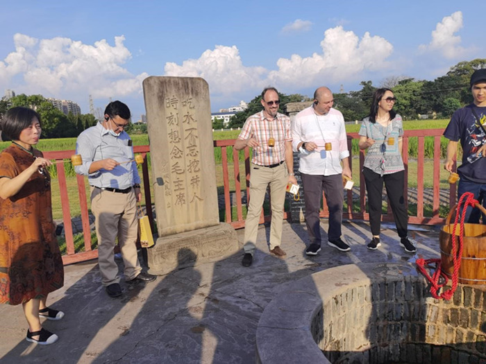 上合组织国家驻华使节来到沙洲坝红井旁,使节们一边品尝井水,一边聆听“饮水思源”的故事。人民网记者 张博岚摄