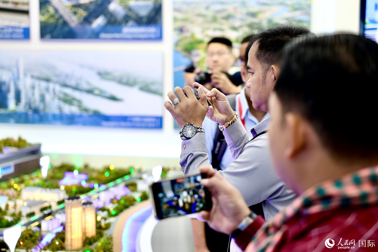 外媒记者在中国能建集团展览馆仿真模型前拍照。人民网 李世奇摄