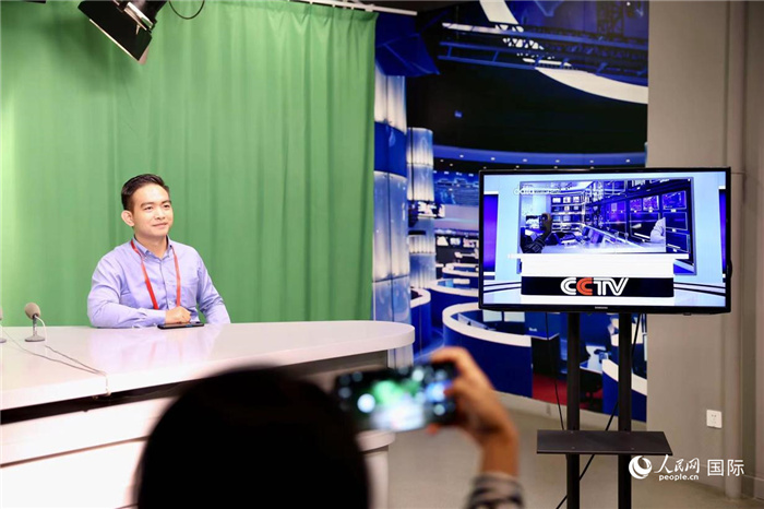 在传媒博物馆内,一名澜湄合作媒体峰会研修班成员体验当新闻主播。人民网 李世奇摄