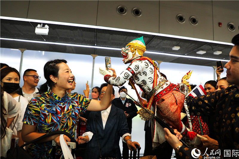 在迎接仪式中,泰国机场工作人员与中国游客友好互动。人民网记者 白元琪摄。