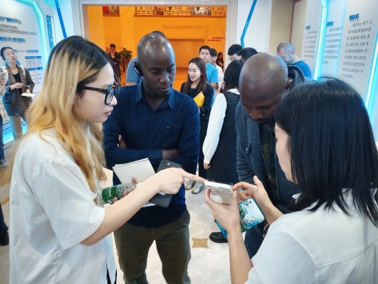 来自肯尼亚的罗杰斯·萨巴纳与来自乌干达的穆巴拉克·穆加贝在工作人员指导下点击查看一款宜宾特色农产品。 摄影 石青川