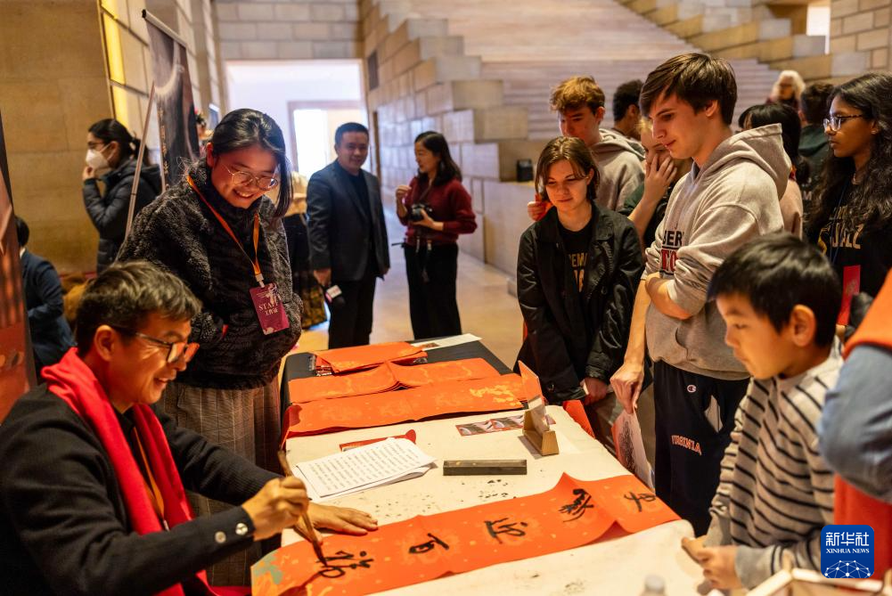 2月11日,书法家在美国费城艺术博物馆举行的龙年迎新春活动上为参观者书写对联。新华社发(周焕新摄)