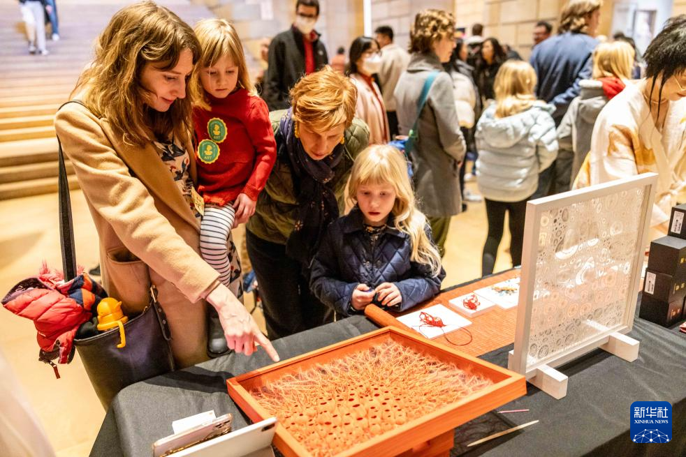 2月11日,参观者在美国费城艺术博物馆举行的龙年迎新春活动上观看刺绣作品。新华社发(周焕新摄)