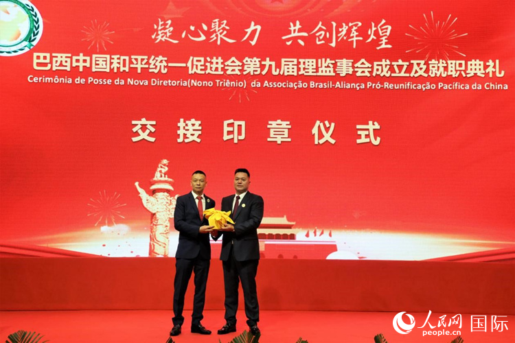 就职典礼中,巴西和统会第七届和第八届会长王俊晓与新任会长张小春交接印章。人民网记者 时元皓摄