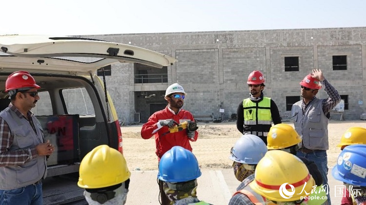 穆萨瓦尔(图中红衣人)现场演示工具操作规范。人民网记者 管克江摄