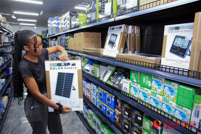 中国商店店员向顾客展示太阳能发电板。恩古巴瓦纳摄