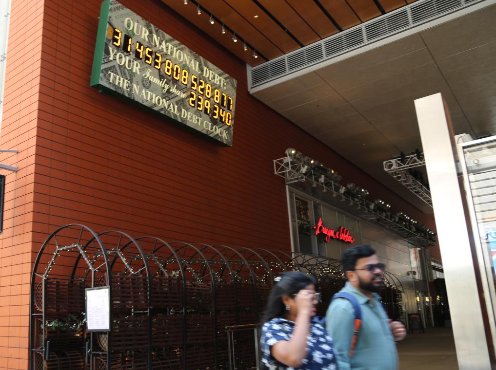 2023年5月29日,人们经过美国纽约曼哈顿的“国债钟”。“国债钟”是一个大型计数器,它实时更新美国的公共债务总额,并显示出每个美国家庭所要负担的数额。新华社记者刘亚南摄