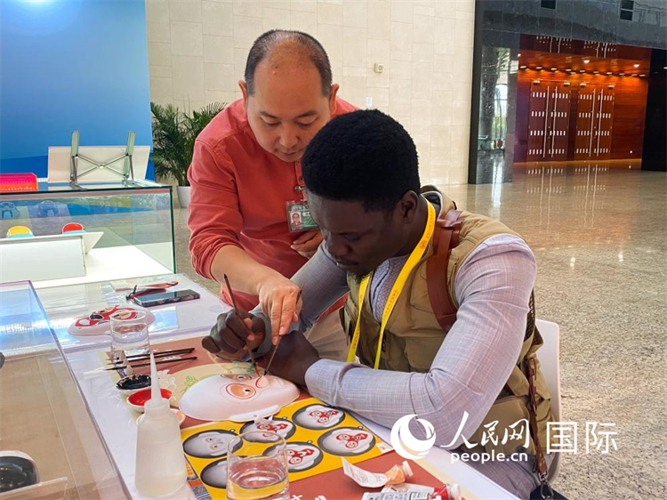 非洲媒体记者在新闻中心体验彩塑京剧脸谱。人民网记者 于洋摄