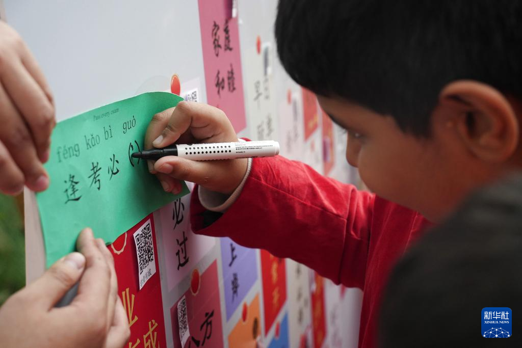 1月10日，在孟加拉国首都达卡，一名男孩在“欢乐春节”庙会上玩填字游戏。新华社记者 孙楠 摄