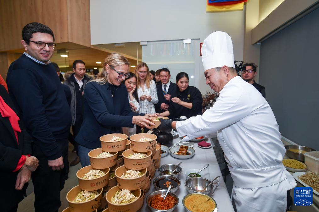 1月20日，在西班牙马德里，人们在“‘你好，中国’重庆美食走进联合国旅游组织——‘渝味360碗’美食推介会”上品尝美食。新华社发（古斯塔沃·巴连特摄）