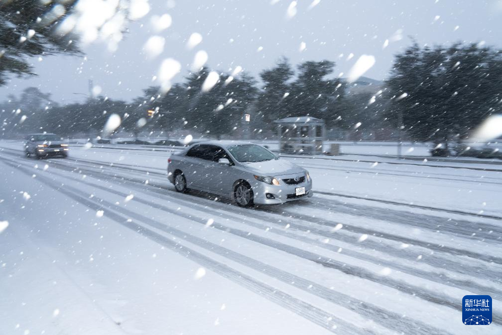 1月21日，在美国休斯敦，车辆在大雪中行驶。新华社发（陈晨摄）