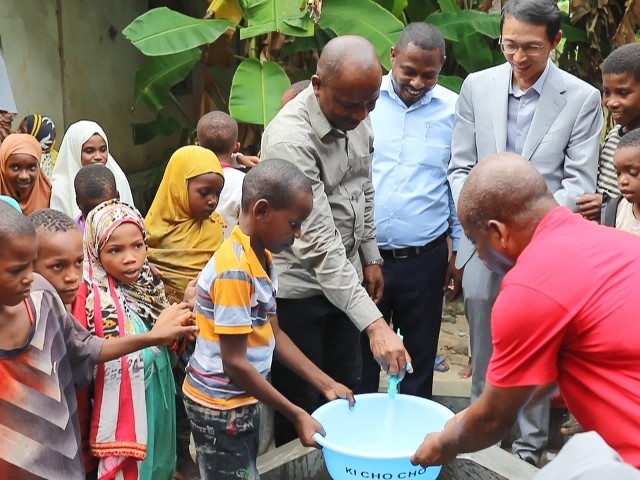 在日前举行的安全供水工程揭牌仪式上，当地小朋友在供水点接水。 施亮摄