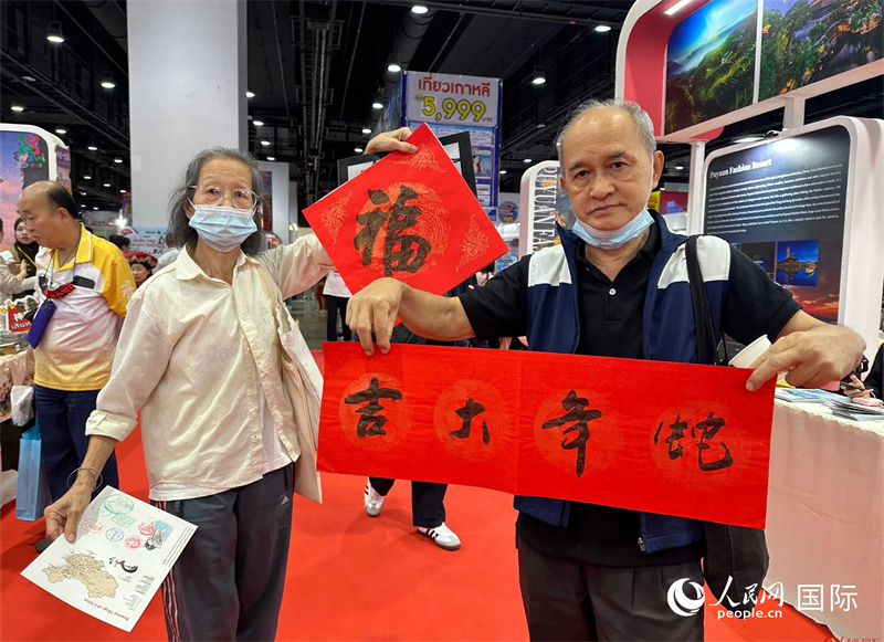 2025蛇年春节，泰国市民展示他们领到的华人手写春联。人民网记者 简承渊摄