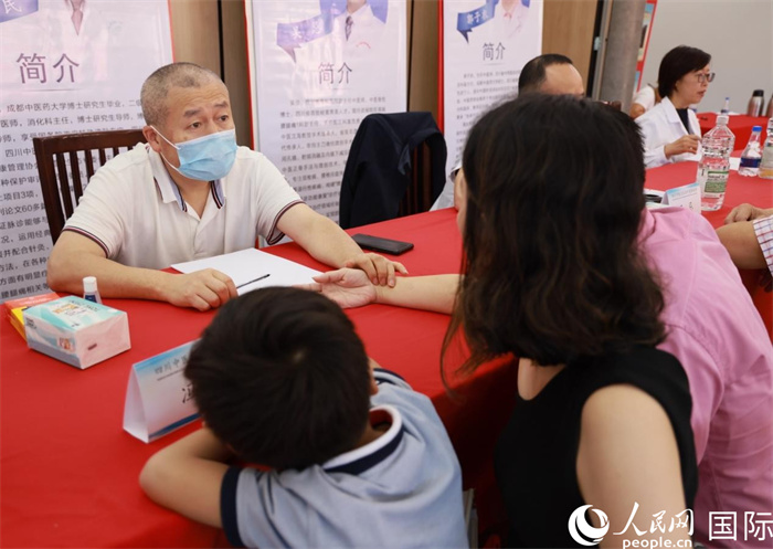 活动现场，成都中医药大学附属医院消化内科主任冯培民正在为当地侨胞把脉。人民网记者 宋亦然摄