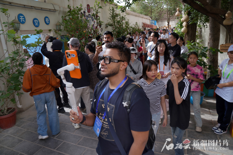 5月24日,在库车市龟兹小巷,一位嘉宾在记录他的所见所闻。