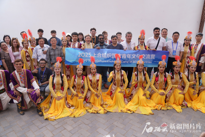 5月24日,在库车市龟兹小巷,交流营嘉宾和当地演员们一起合影留念。