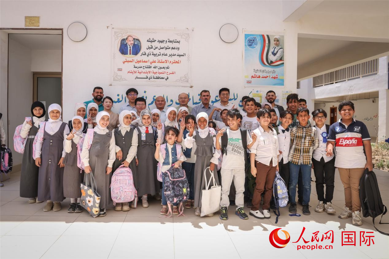 图为中企项目工作人员与法拉赫学校师生合影。人民网记者 薛丹摄