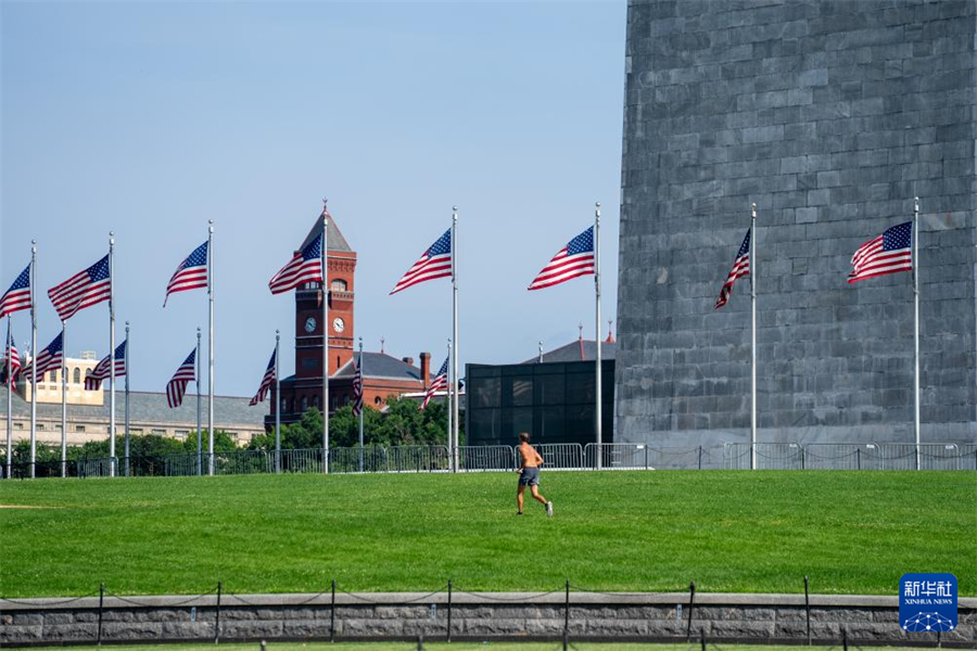 6月23日，在美国首都华盛顿，一名男子在草地上跑步。新华社记者 胡友松 摄