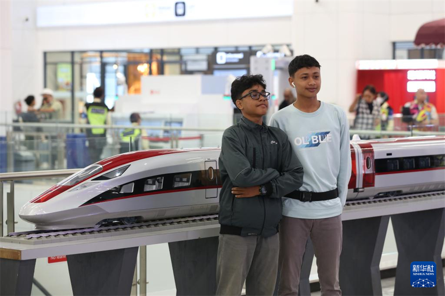 6月19日，在印度尼西亚雅加达，两名乘客在雅万高铁哈利姆站候车大厅与雅万高铁高速动车组模型合影。新华社记者 岑云鹏 摄
