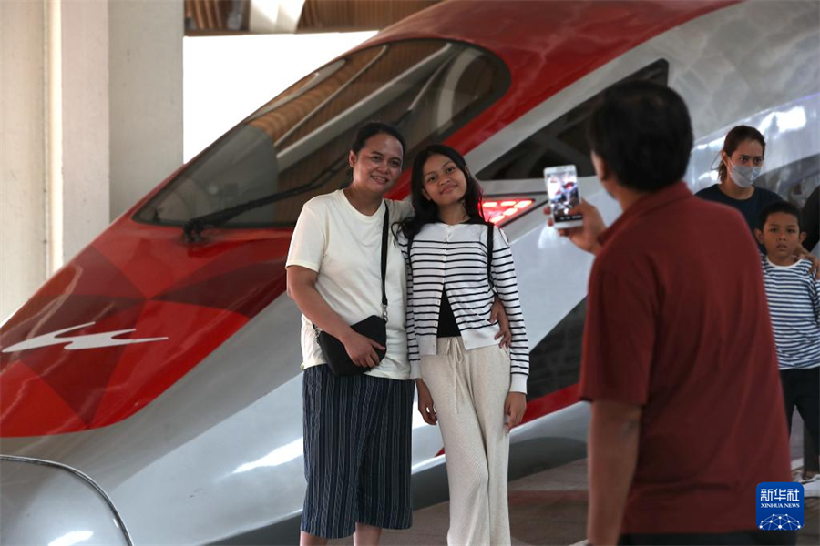 6月19日，在印度尼西亚雅加达哈利姆站站台，两名乘客与雅万高铁高速动车组列车合影。新华社记者 岑云鹏 摄