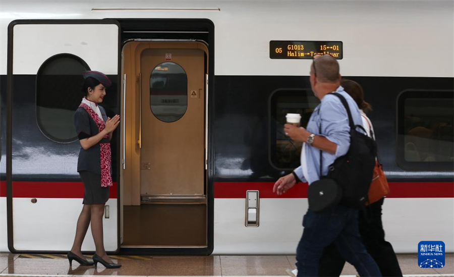 6月19日，一名乘务人员在印度尼西亚雅加达哈利姆站站台欢迎乘客。新华社记者 岑云鹏 摄