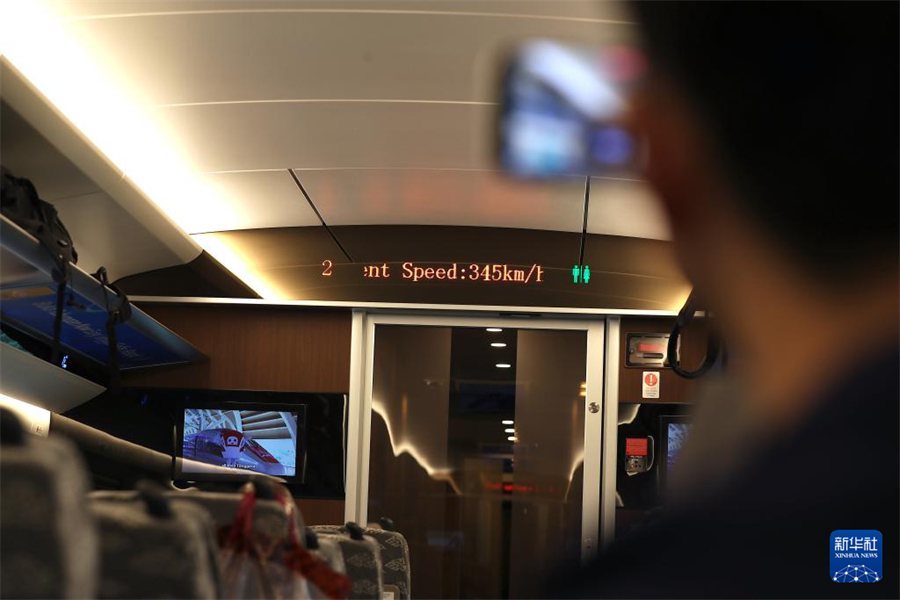 6月19日，一名乘客在行驶中的雅万高铁车厢内拍摄列车时速。新华社记者 岑云鹏 摄