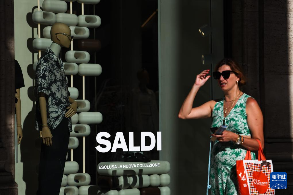 7月5日，在意大利罗马，一名女子经过商店橱窗。新华社记者 李京 摄