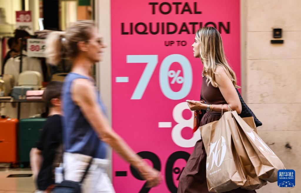 7月5日，一名女子提着购物袋走在意大利罗马街头。新华社记者 李京 摄