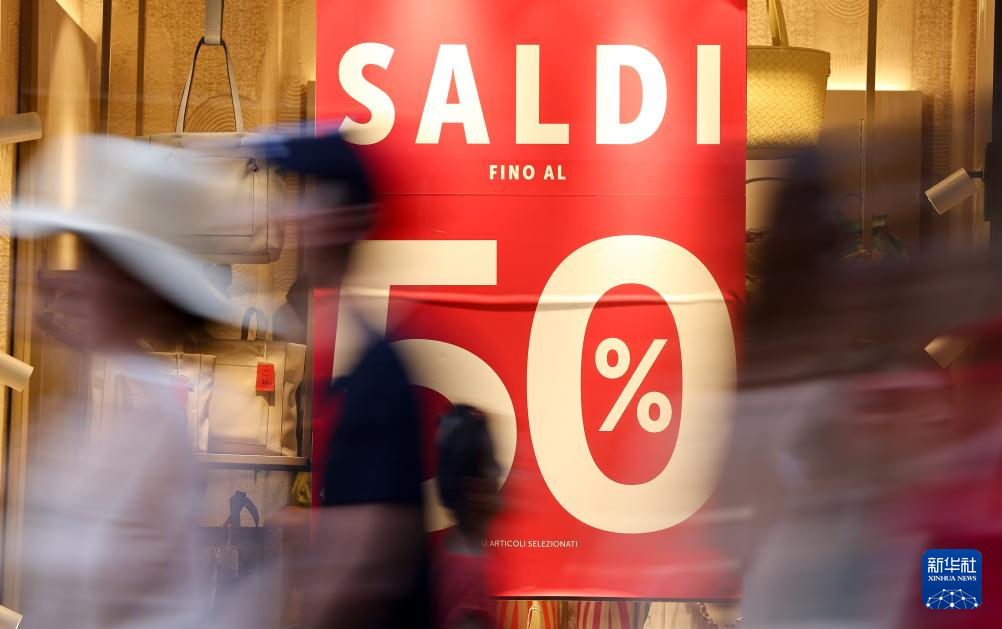 7月5日，在意大利罗马，人们经过一处商店橱窗。新华社记者 李京 摄