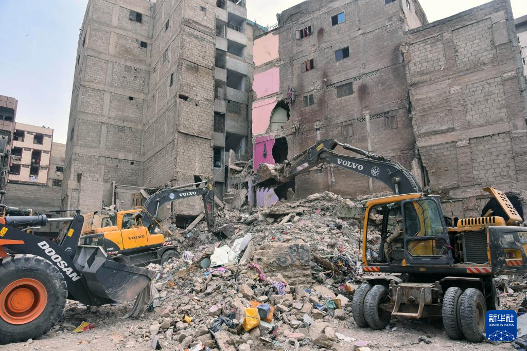 7月5日，在巴基斯坦南部港口城市卡拉奇，救援人员在住宅楼废墟中开展搜救工作。新华社发