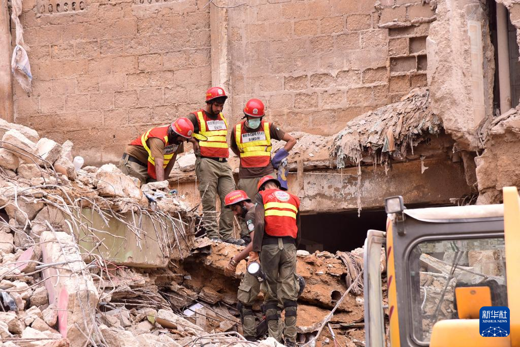 7月5日，在巴基斯坦南部港口城市卡拉奇，救援人员在住宅楼废墟中开展搜救工作。新华社发