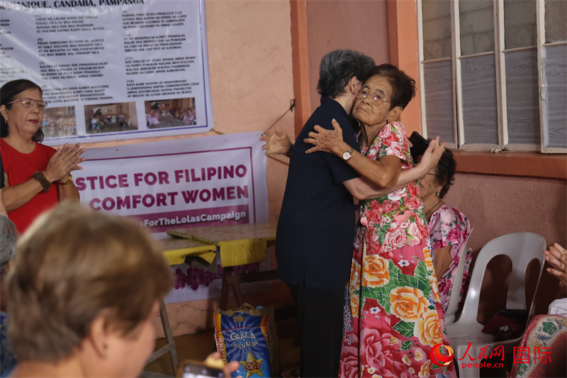 菲律宾华裔青年联合会创会会长洪玉华与马帕尼克村慰安妇幸存者拥抱。人民网记者樊帆 摄