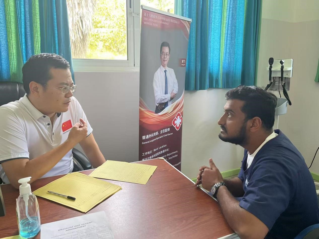 医疗队队员宋飞在义诊现场接受患者咨询。医疗队供图