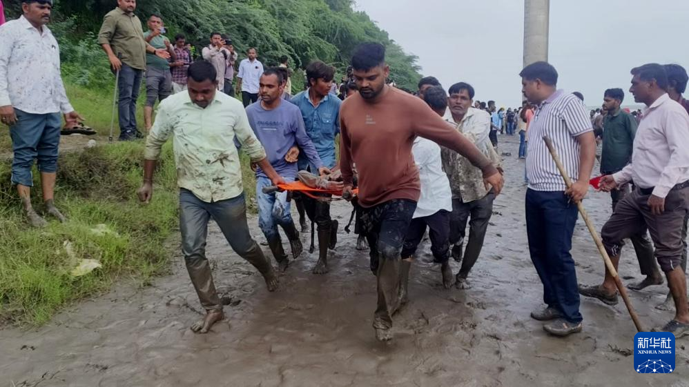 7月9日，救援人员在印度西部古吉拉特邦垮塌的桥梁旁开展救援行动。新华社/印度联合新闻社