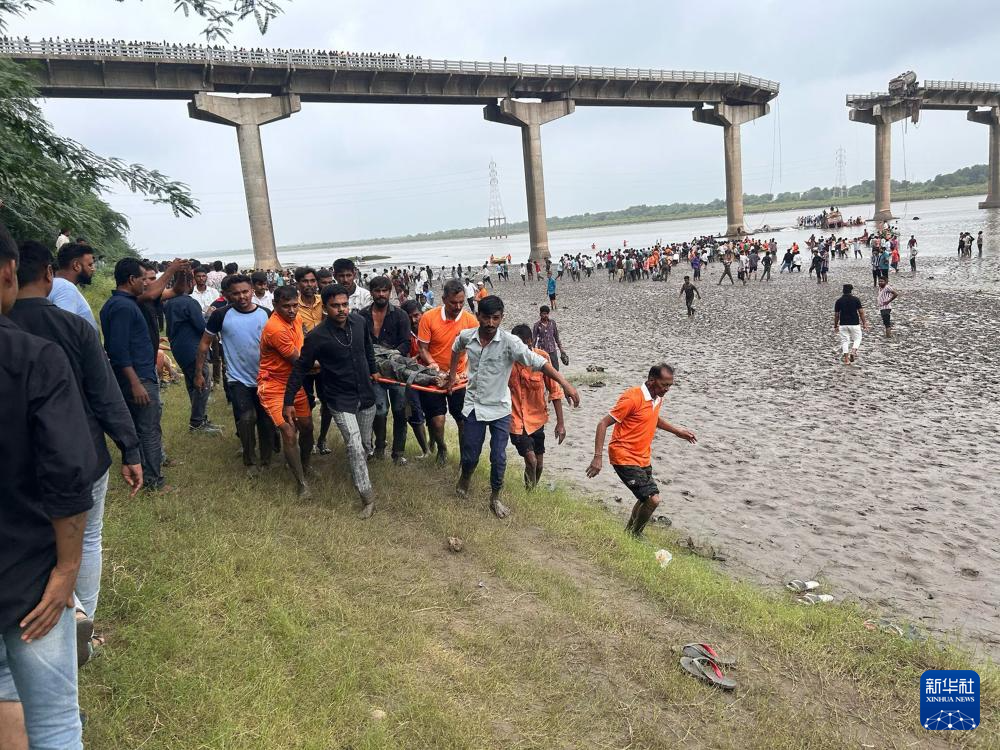 7月9日，救援人员在印度西部古吉拉特邦垮塌的桥梁旁开展救援行动。新华社/印度联合新闻社