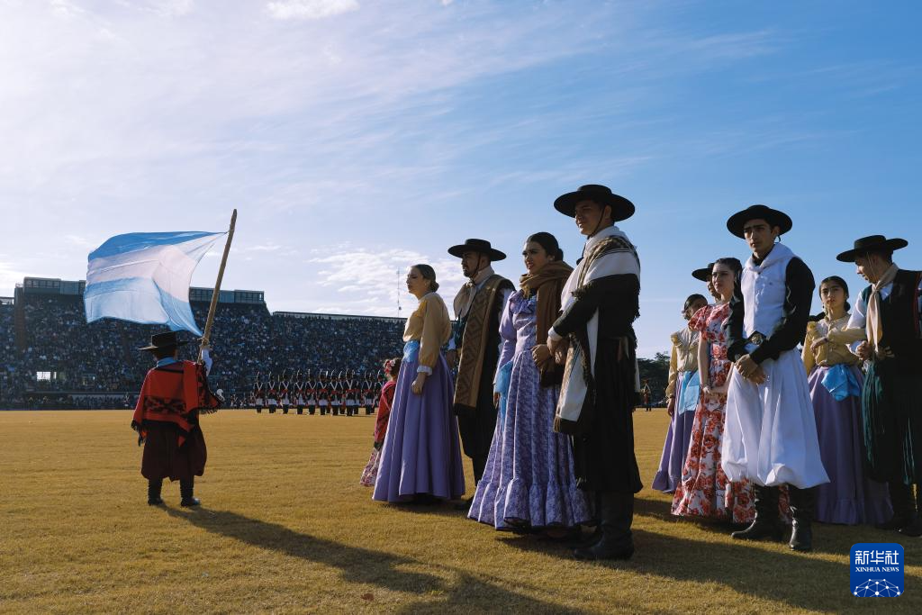 7月9日，在阿根廷首都布宜诺斯艾利斯，穿着传统服饰的民众参加军乐节。新华社记者 孟鼎博 摄