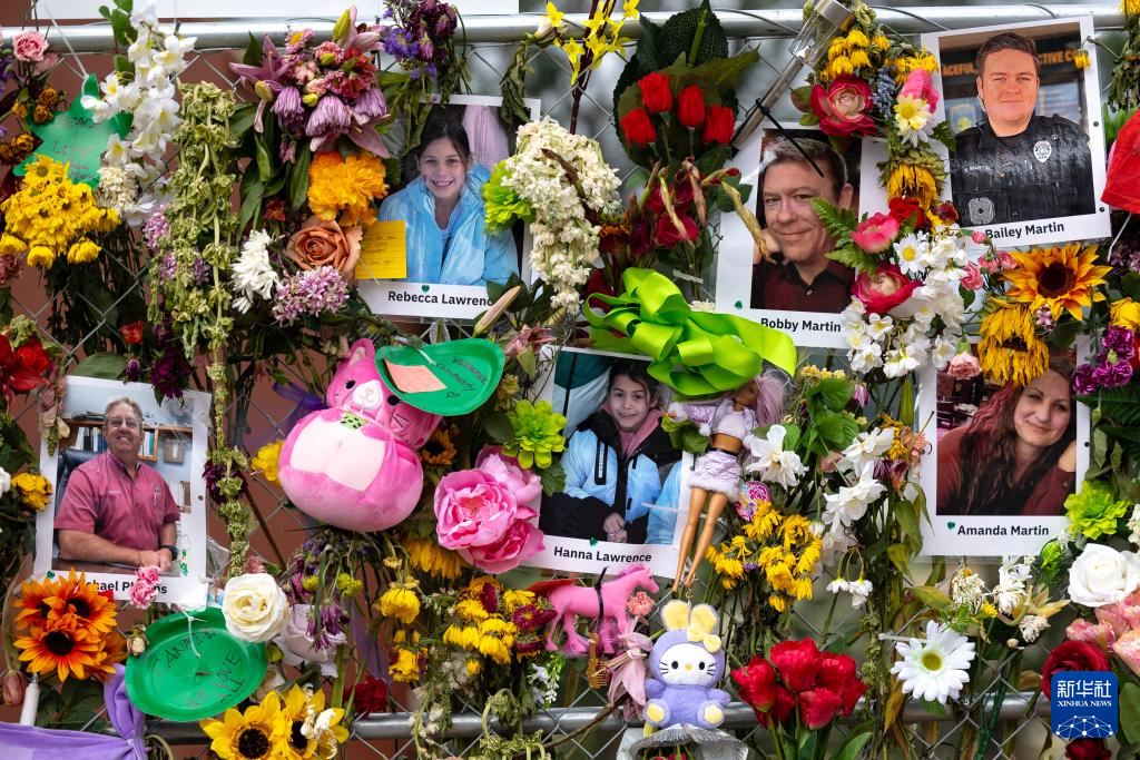 7月12日，在美国得克萨斯州克尔维尔，人们将悼念的鲜花插在洪灾遇难者的照片旁。新华社发（尼克·瓦格纳摄）