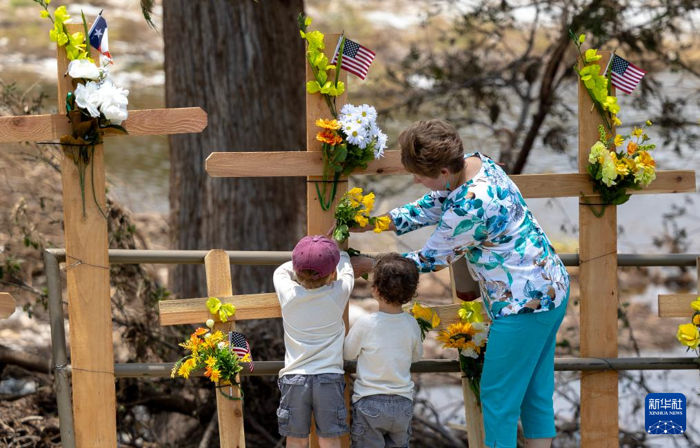 7月12日，人们在美国得克萨斯州克尔维尔献花悼念洪灾遇难者。新华社发（尼克·瓦格纳摄）