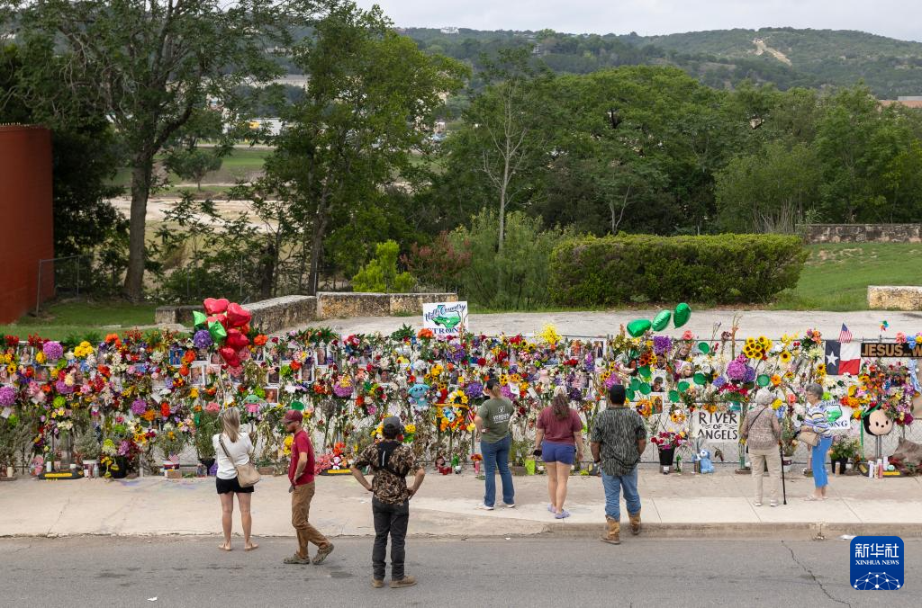 7月12日，人们在美国得克萨斯州克尔维尔一处临时纪念场所悼念洪灾遇难者。新华社发（尼克·瓦格纳摄）