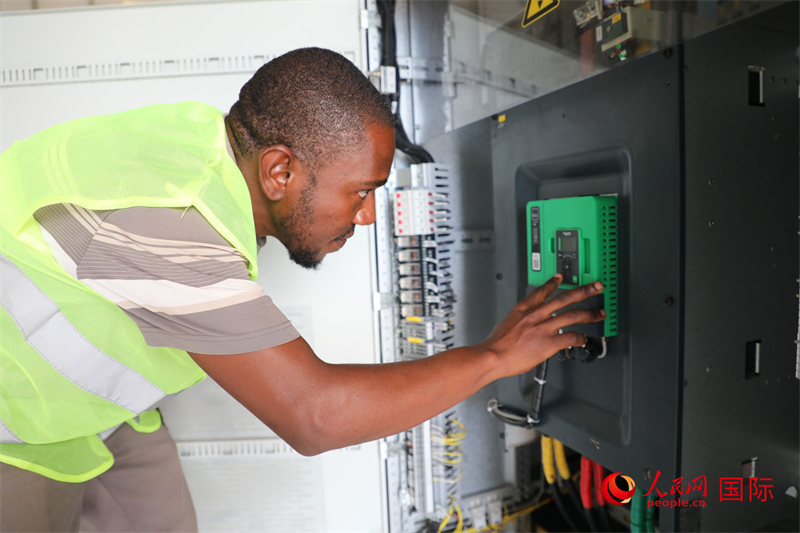 当地员工尼永姆正在水泵站检查高低压配电设备。人民网记者 沈小晓摄