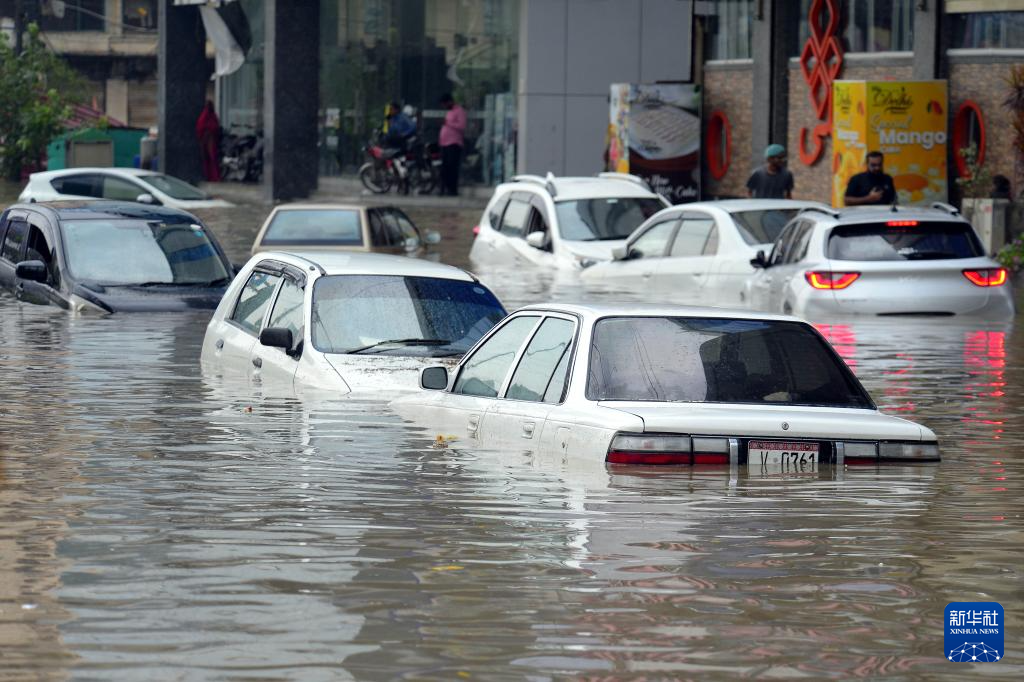 8月19日，在巴基斯坦南部港口城市卡拉奇，暴雨过后车辆浸泡在积水中。新华社发