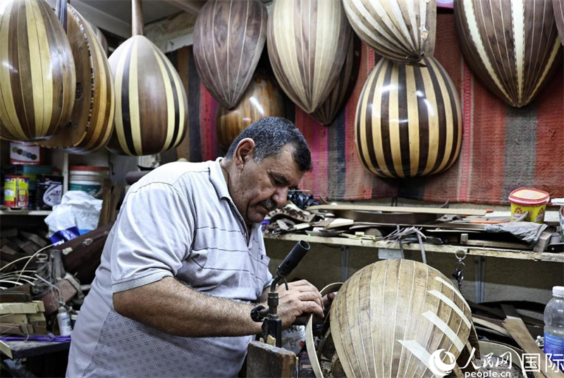 阿里·阿勒阿卜达迪正在粘贴乌德琴琴身木板。人民网伊纳斯·易卜拉欣摄