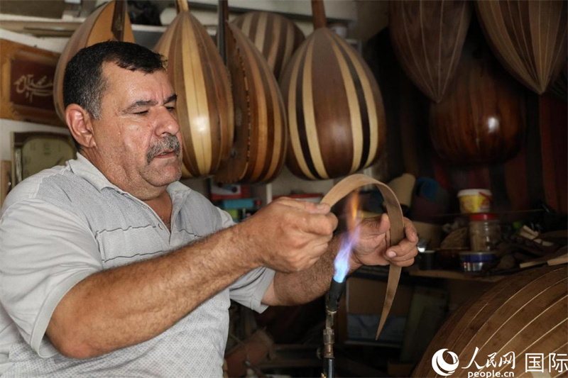 阿里·阿勒阿卜达迪在烘烤乌德琴琴身木板。人民网伊纳斯·易卜拉欣摄