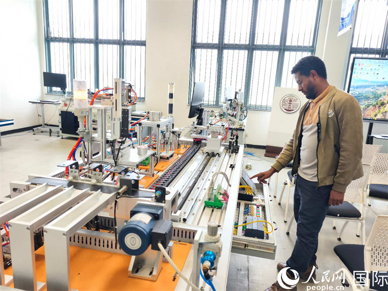 鲁班坊Yihun老师正在检测模拟工业自动化平台设备。人民网记者 黄培昭摄