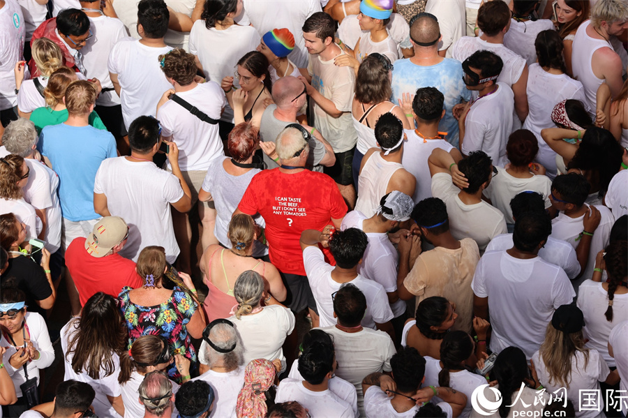 图为各国游客前往“西红柿大战”会场。人民网记者 颜欢摄